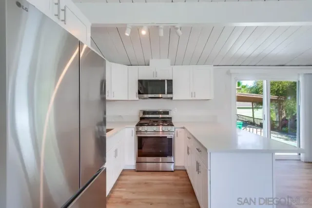 a kitchen with stainless steel appliances a stove a sink and a refrigerator