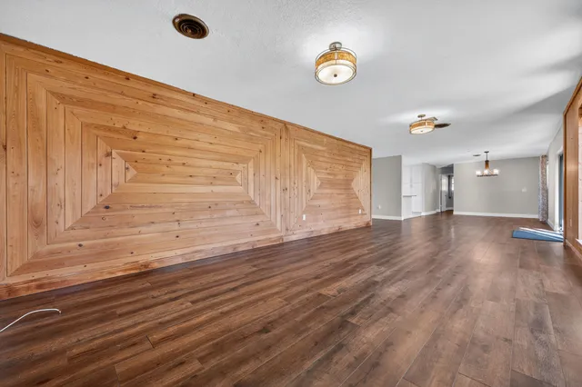 a view of empty room with wooden floor