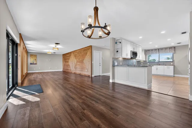 a view of a kitchen with a sink a refrigerator and wooden floor