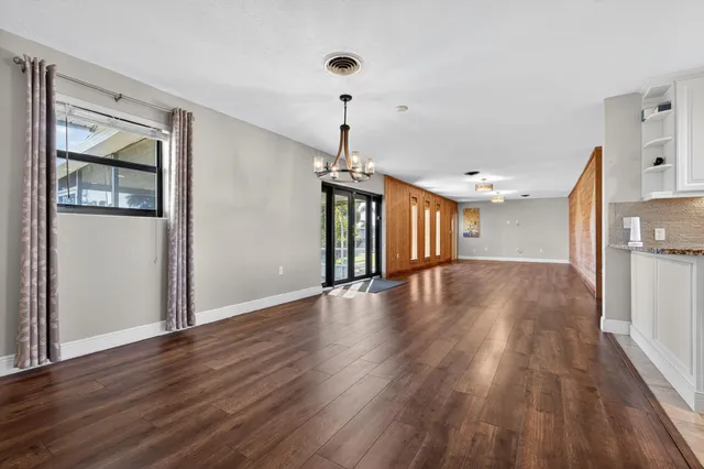 a view of empty room with wooden floor