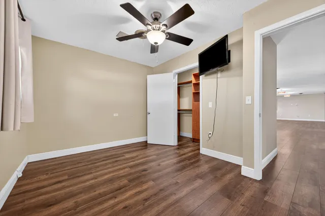 a view of an empty room with wooden floor
