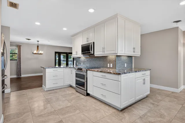 a kitchen with stainless steel appliances granite countertop a stove and a sink
