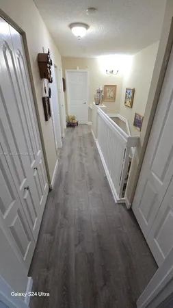 a view of a hallway with wooden floor
