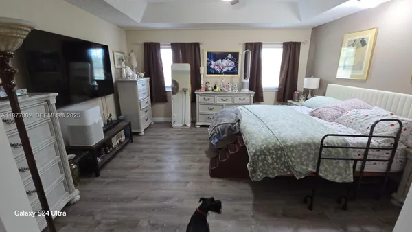 a bedroom with a bed and a flat tv screen on the dresser