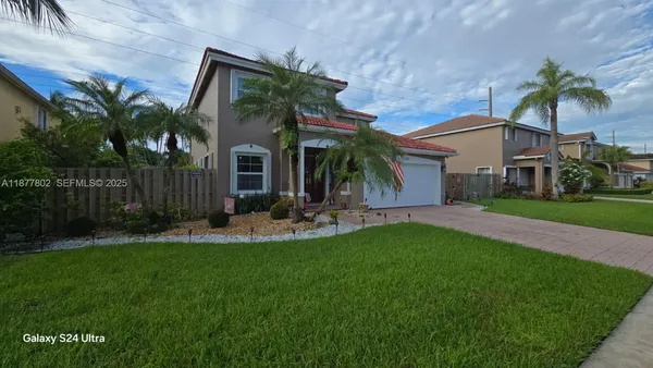 a front view of house with yard and green space
