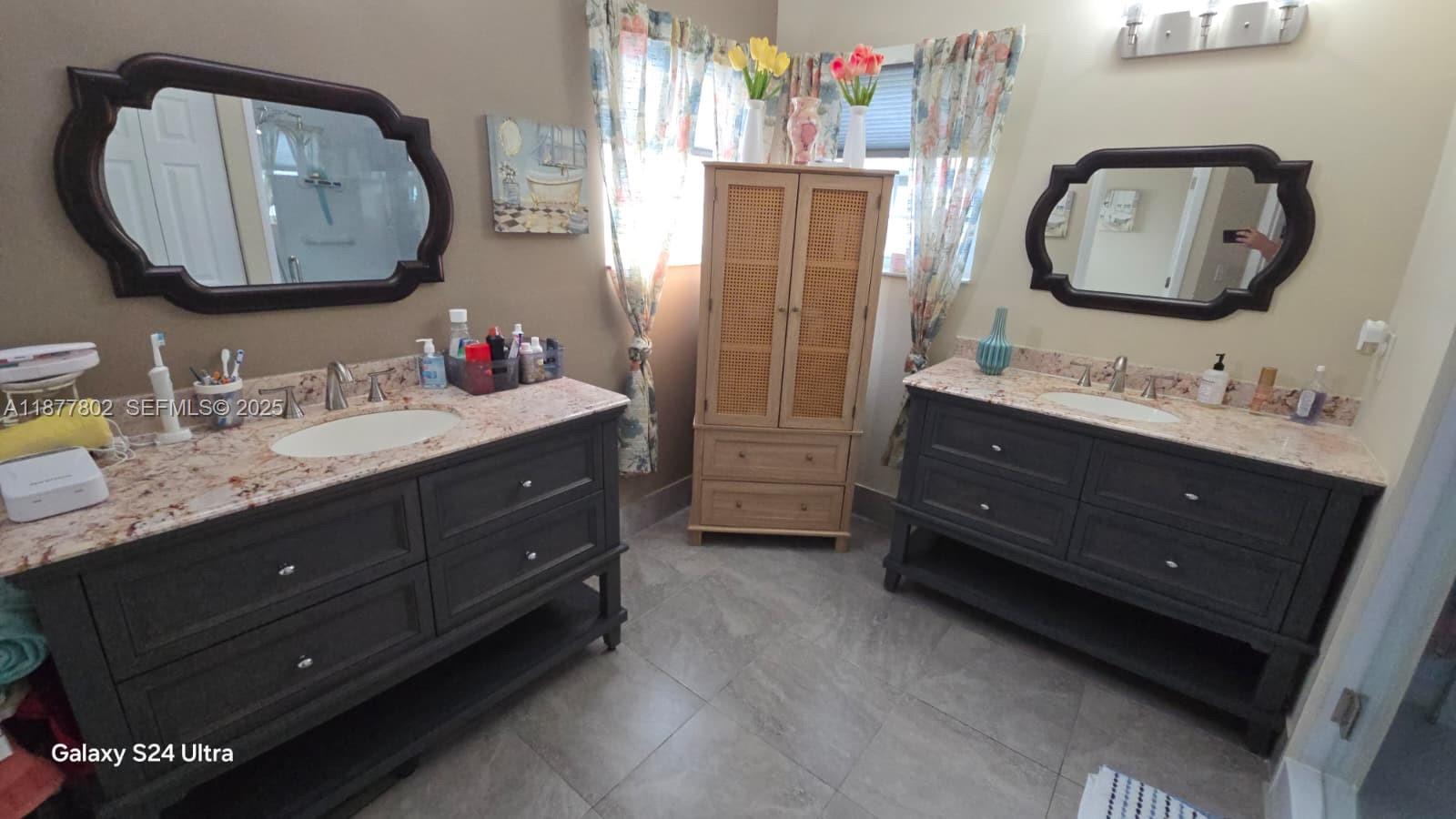 15436 Southwest 151st Terrace Miami, FL 33196 - Photo 21 of 50 a bathroom with a double vanity sink and a mirror