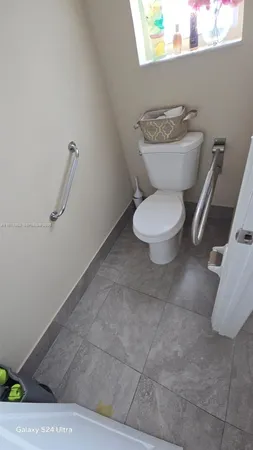 a bathroom with a toilet a sink and a mirror