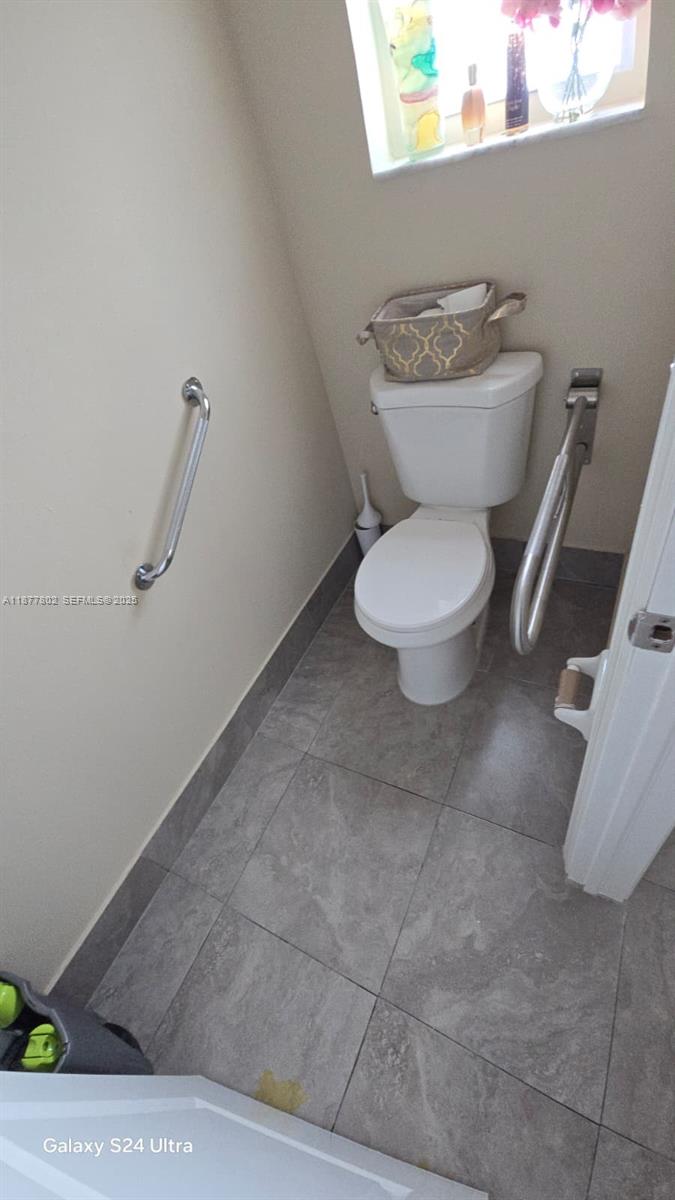 15436 Southwest 151st Terrace Miami, FL 33196 - Photo 24 of 50 a bathroom with a toilet a sink and a mirror