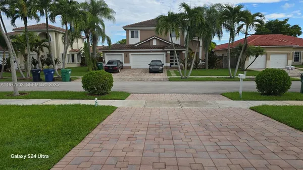 a view of a house with a big yard and potted plants