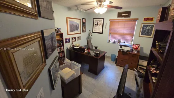 a view of a workspace with furniture and a window
