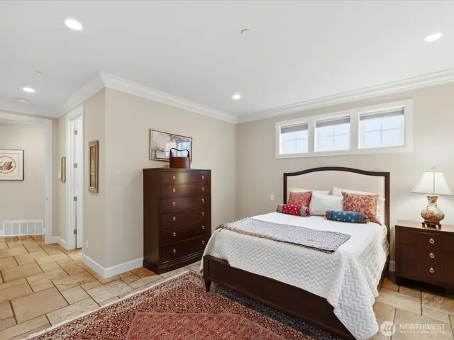 a bedroom with a bed and a lamp on dresser