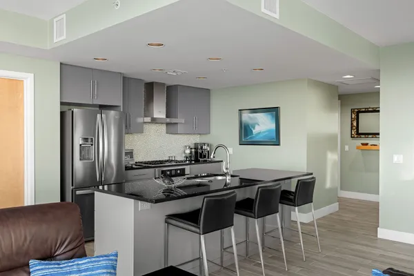 a kitchen with stainless steel appliances granite countertop a refrigerator and a stove top oven