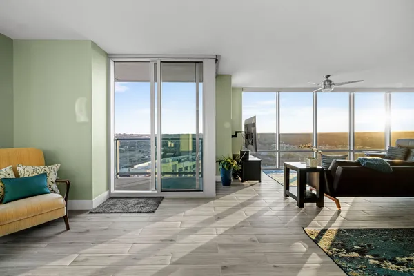 a living room with furniture and floor to ceiling window