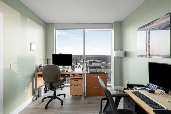 a view of a workspace with furniture and a window