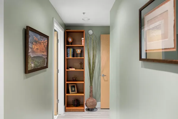 a view of a hallway with wooden floor and windows