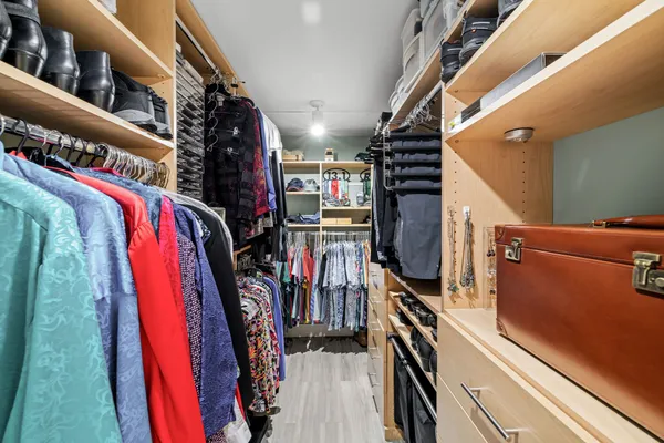 a view of walk in closet with clothes and shoes