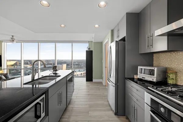 a kitchen with stainless steel appliances a sink stove and cabinets