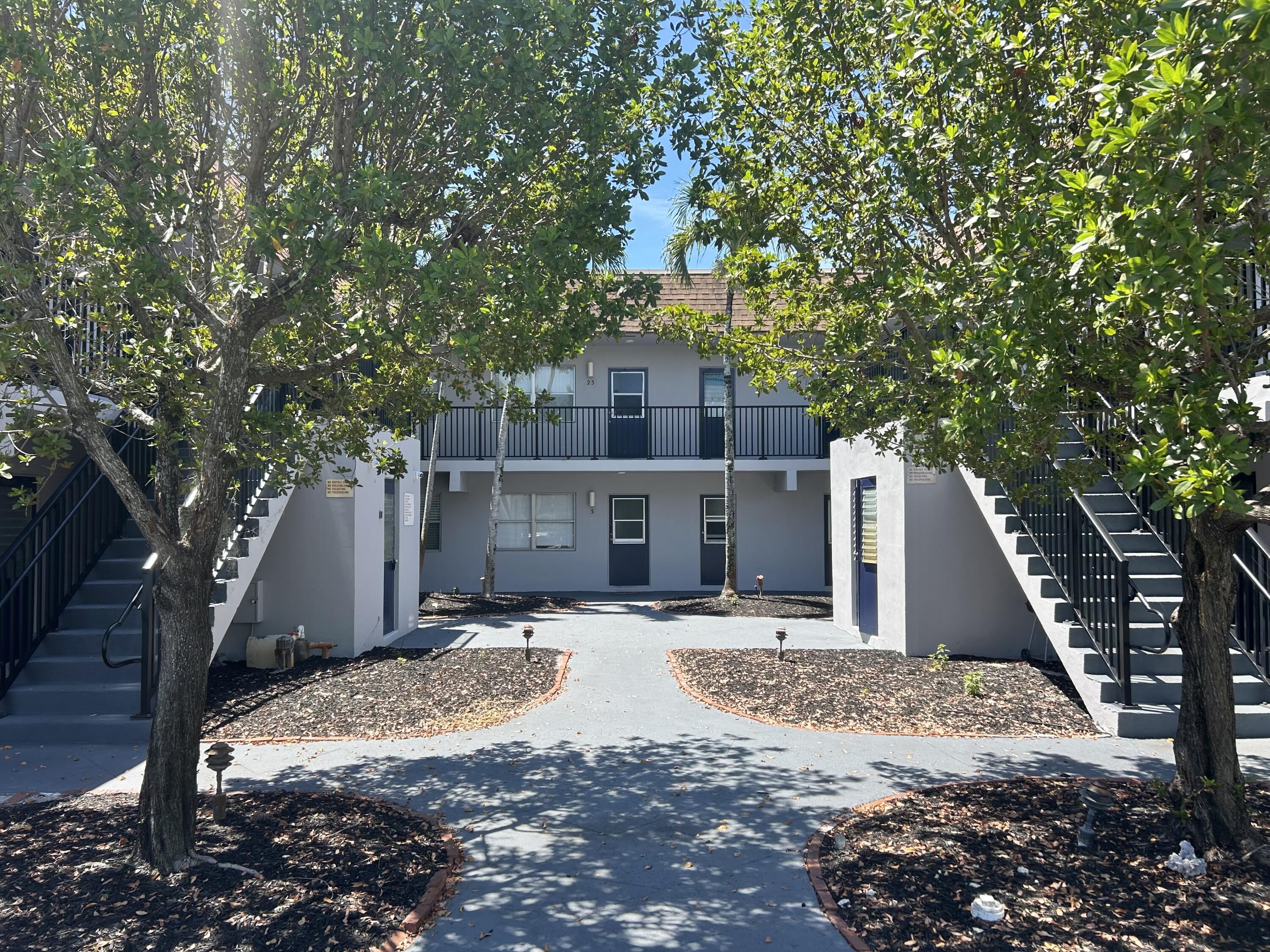 260 Northwest 19th Street, Unit 290 Boca Raton, FL 33432 - Photo 2 of 18 a front view of a house with a yard and garage