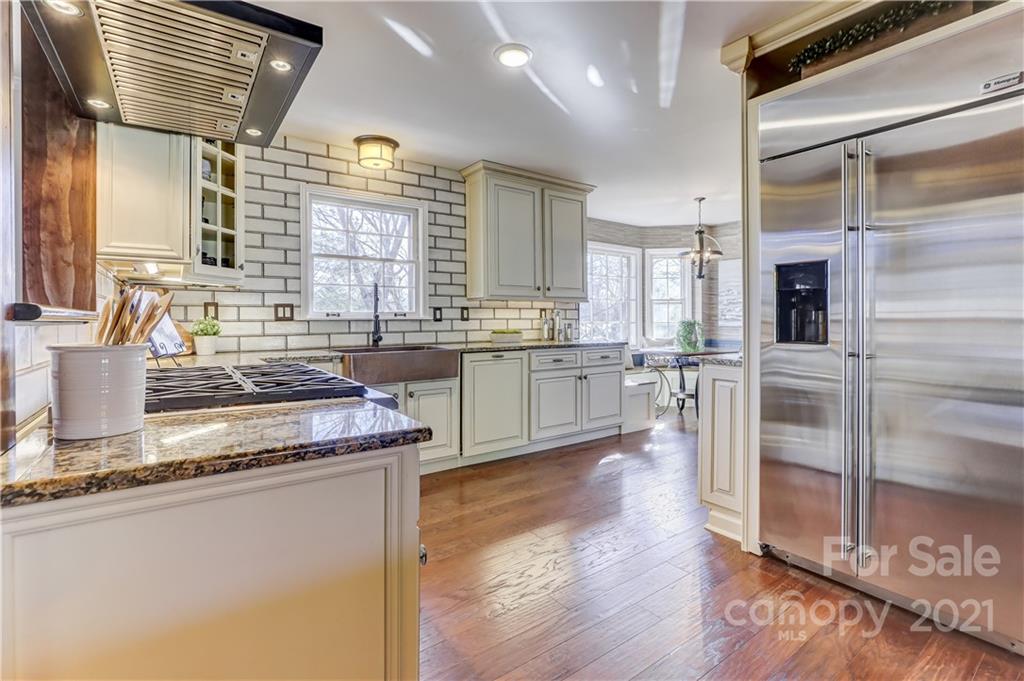 a kitchen with stainless steel appliances granite countertop a stove a sink and a refrigerator