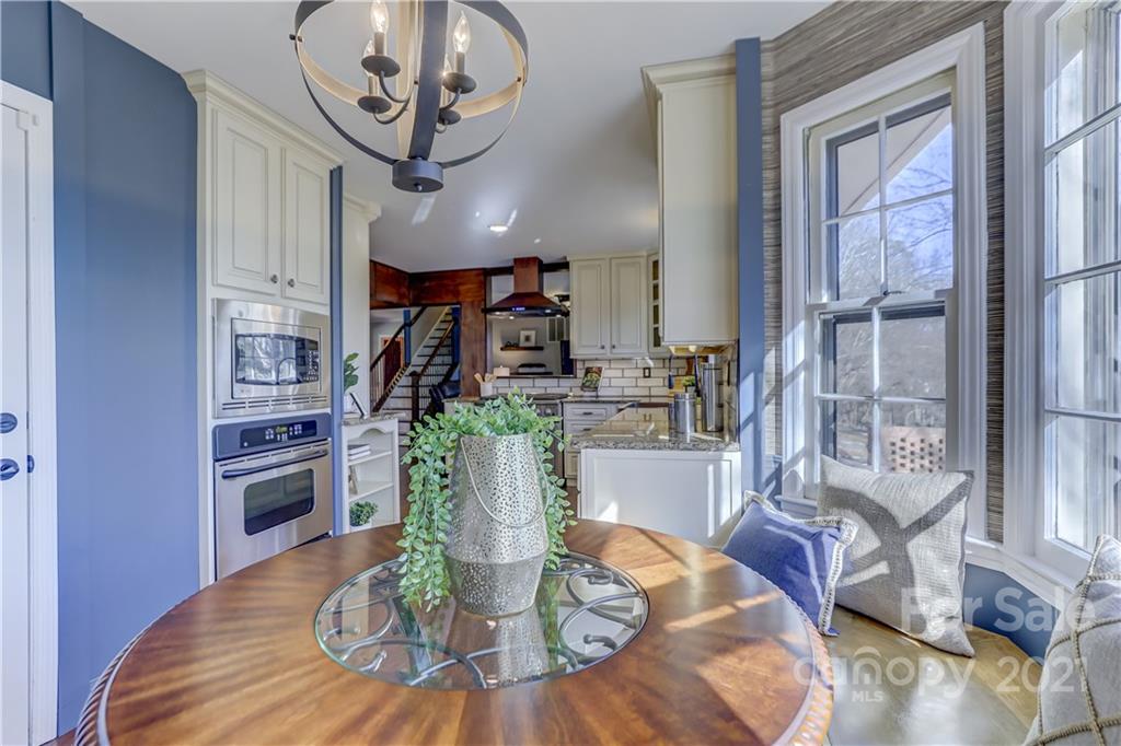 6601 Sharon Road Charlotte, NC 28210 - Photo 13 of 46 a dining room with wooden floor a chandelier a glass table and chairs