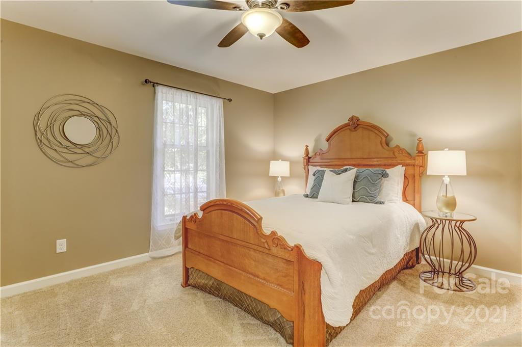 6601 Sharon Road Charlotte, NC 28210 - Photo 24 of 46 a bedroom with a bed and a chandelier