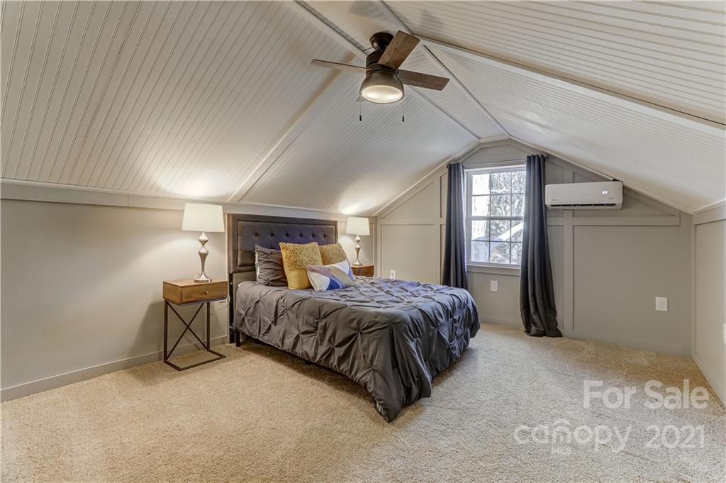 6601 Sharon Road Charlotte, NC 28210 - Photo 32 of 46 a spacious bedroom with a bed and a chandelier