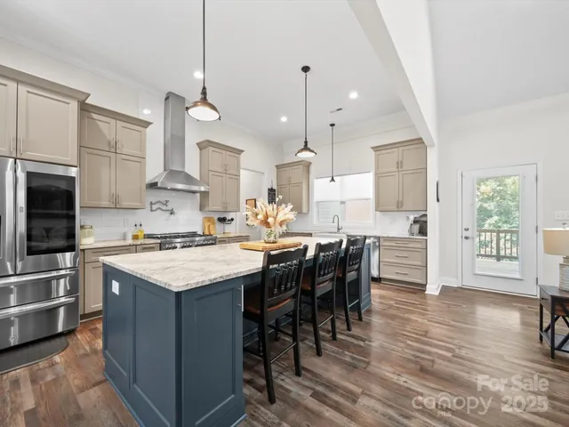 a kitchen with stainless steel appliances a stove a sink a refrigerator a center island and a stove