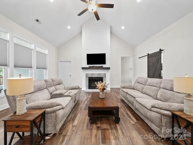 a living room with furniture a fireplace and a flat screen tv