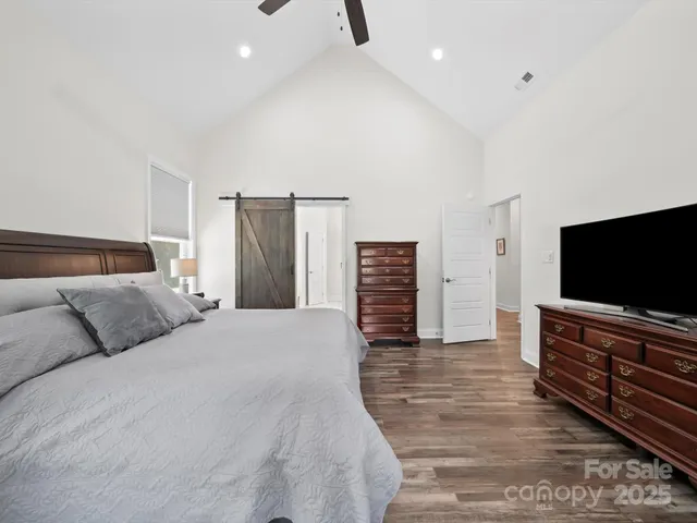 a bedroom with furniture and a flat screen tv