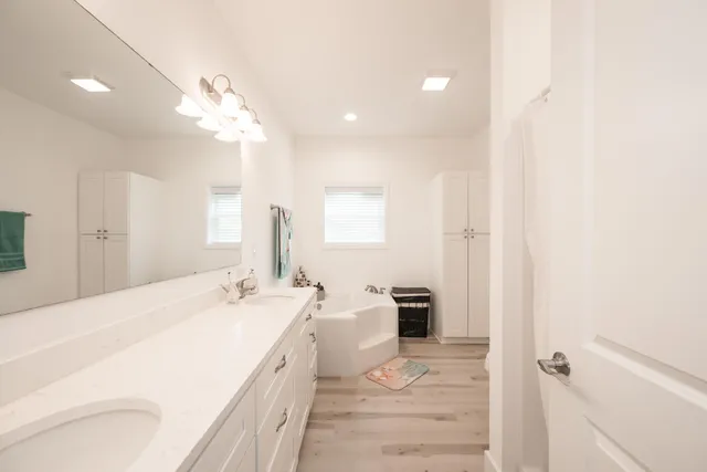 a spacious bathroom with a double vanity sink a mirror and a shower