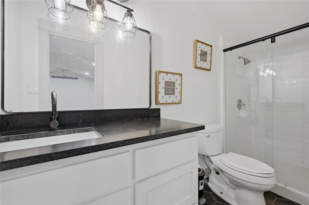 140 Turkey Farm Road Whitesboro, TX 76273 - Photo 19 of 38 a bathroom with a granite countertop sink toilet a mirror and shower