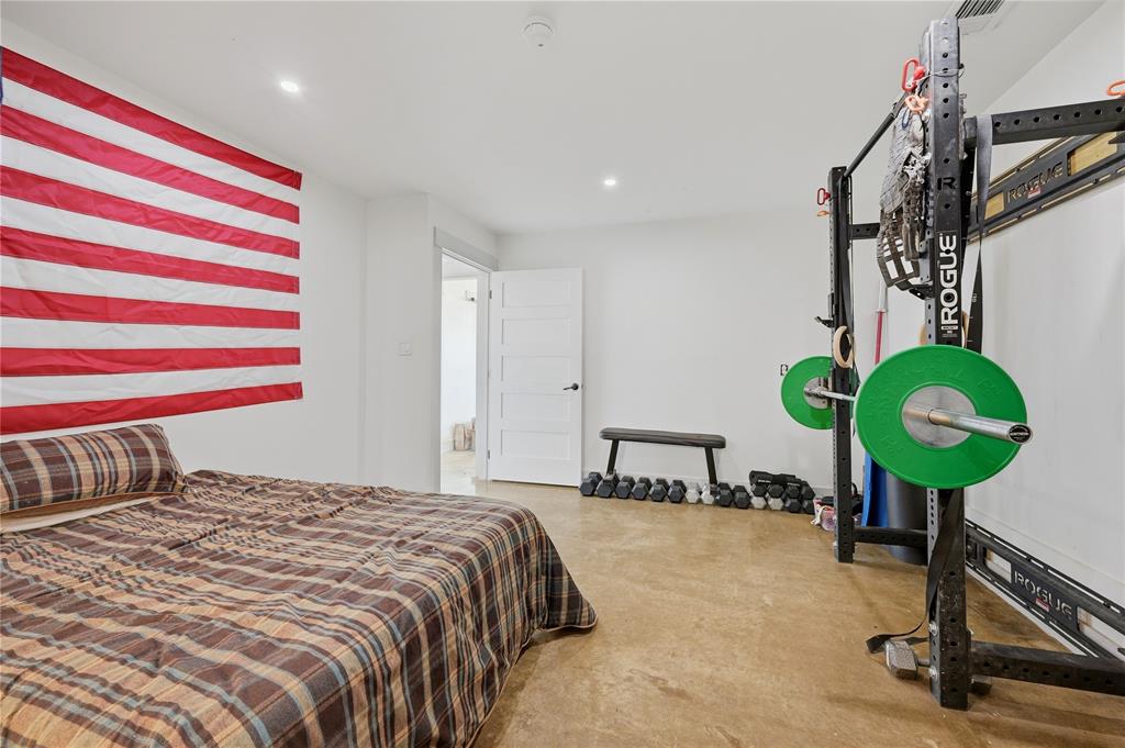 140 Turkey Farm Road Whitesboro, TX 76273 - Photo 28 of 38 a bedroom with a bed and a chandelier