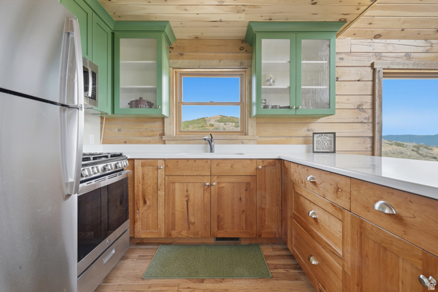 20 Q Puma Road Fairview, UT 84629 - Photo 7 of 27 Kitchen featuring natural wood cabinetry, light green upper cabinets with glass fronts, and white countertops
