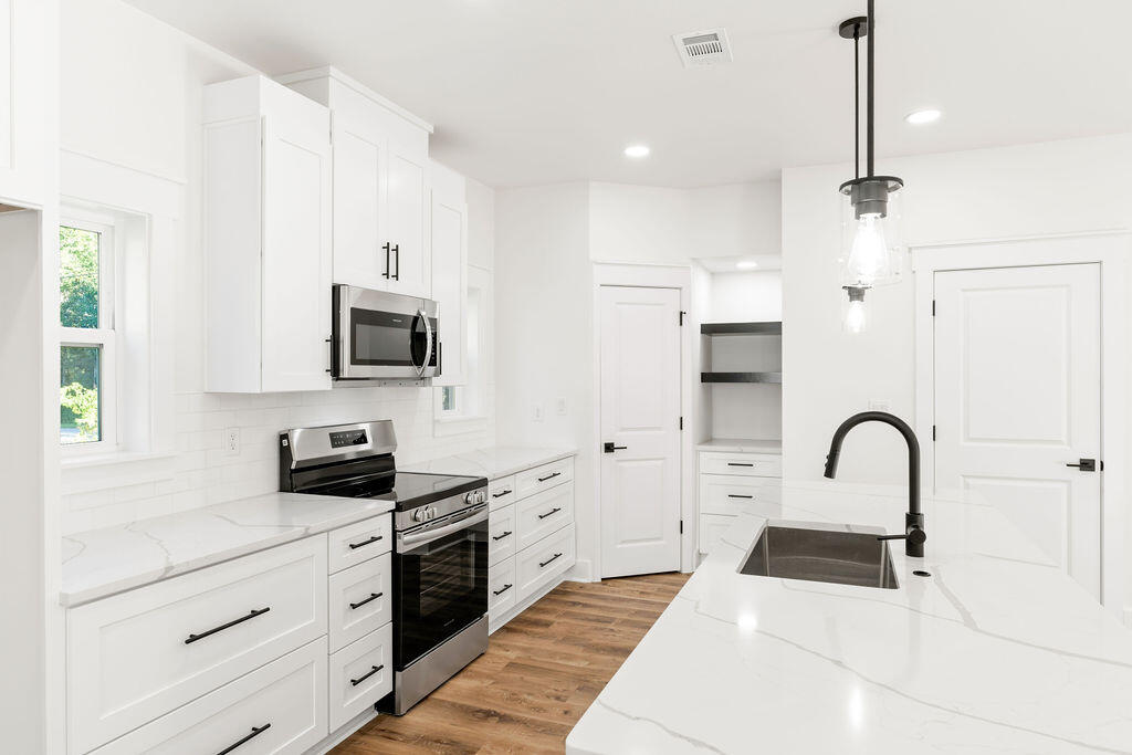 32 22nd Street Santa Rosa Beach, FL 32459 - Photo 7 of 26 a kitchen with a sink white cabinets and stainless steel appliances