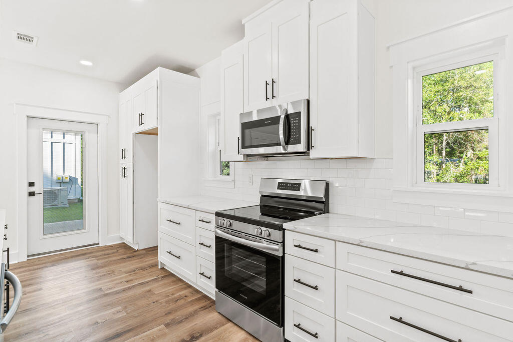 32 22nd Street Santa Rosa Beach, FL 32459 - Photo 9 of 26 a kitchen with stainless steel appliances white cabinets and a stove top oven