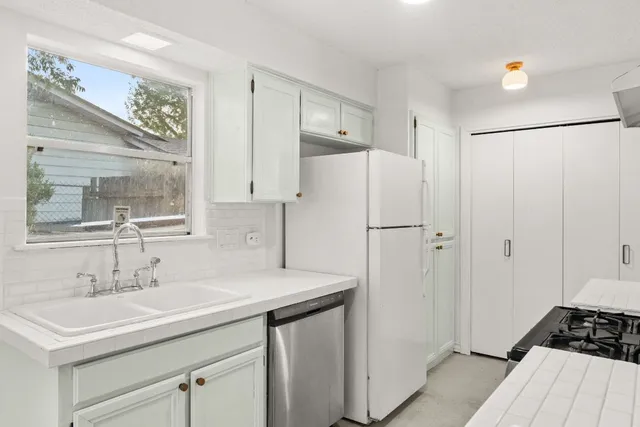 a kitchen with a sink appliances and cabinets