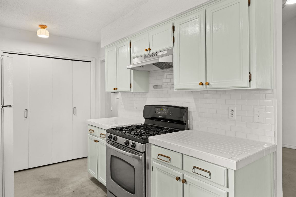 5413 Duval Street Austin, TX 78751 - Photo 22 of 27 a kitchen with stainless steel appliances white cabinets and a stove