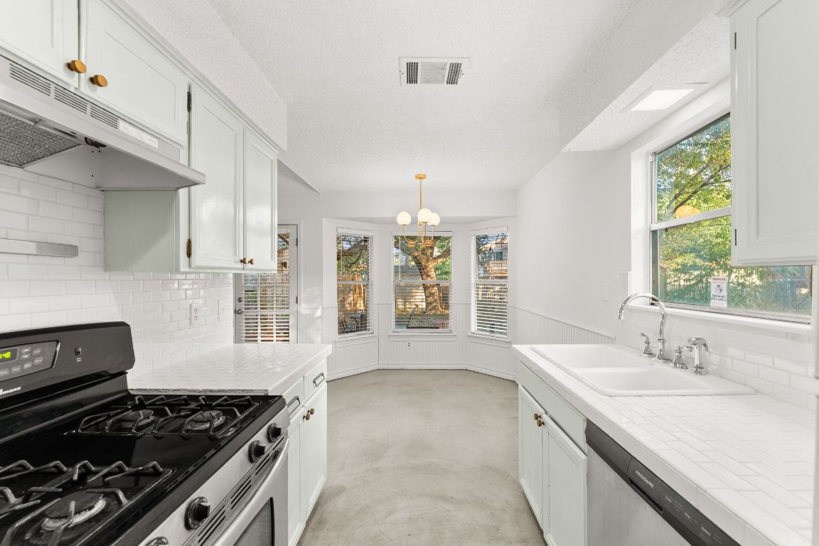 5413 Duval Street Austin, TX 78751 - Photo 23 of 27 a kitchen with a sink stove and cabinets