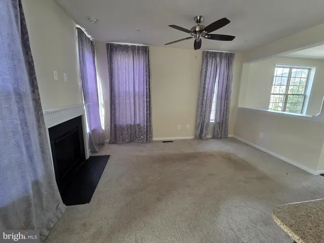 an empty room with windows and a fireplace