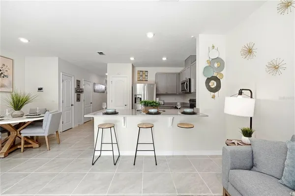 a kitchen with stainless steel appliances kitchen island granite countertop a table and chairs in it