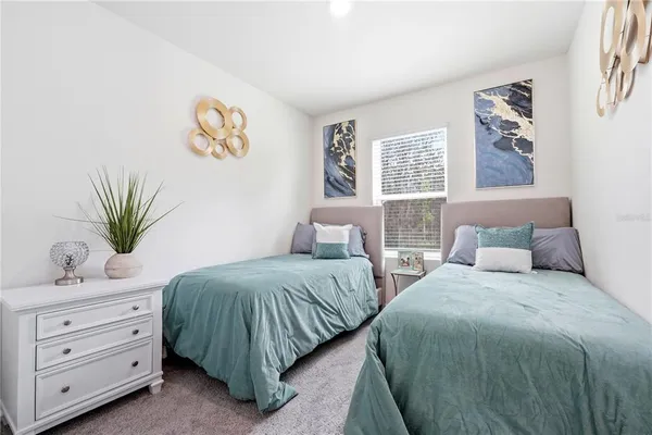 a bedroom with two beds and painting on the wall
