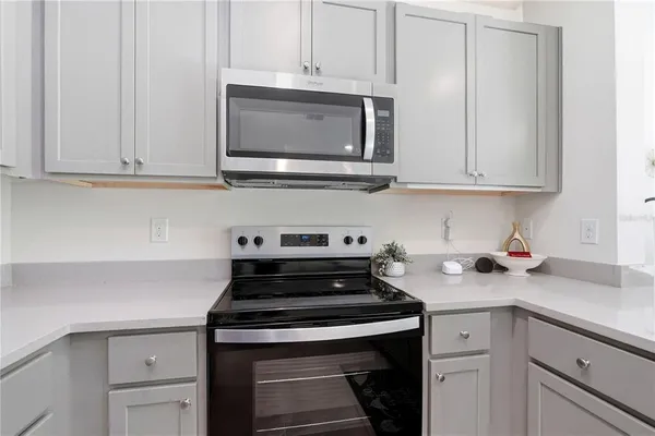 a kitchen with granite countertop white cabinets and stainless steel appliances