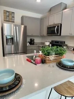 a kitchen with stainless steel appliances a microwave a sink and cabinets