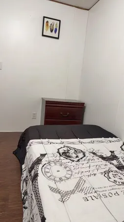a bedroom with a bed and a wooden floor
