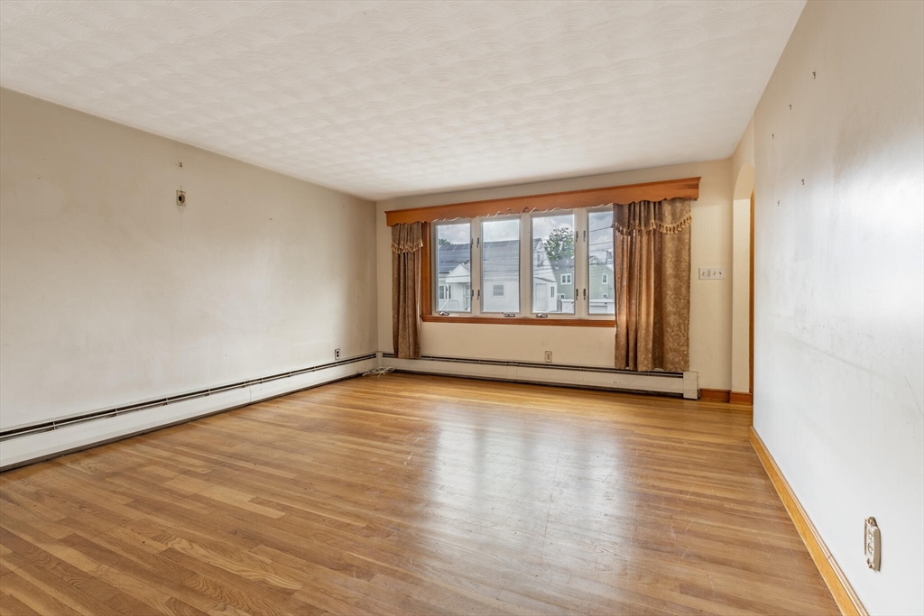 17 Albert Park Everett, MA 02149 - Photo 12 of 40 a view of an empty room with wooden floor and a window