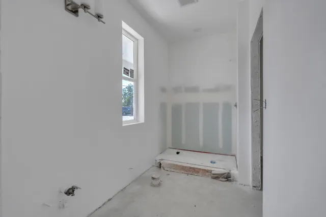 an empty room with a ceiling fan and a window