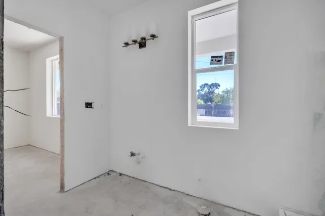 a view of a hallway with wooden floor and windows