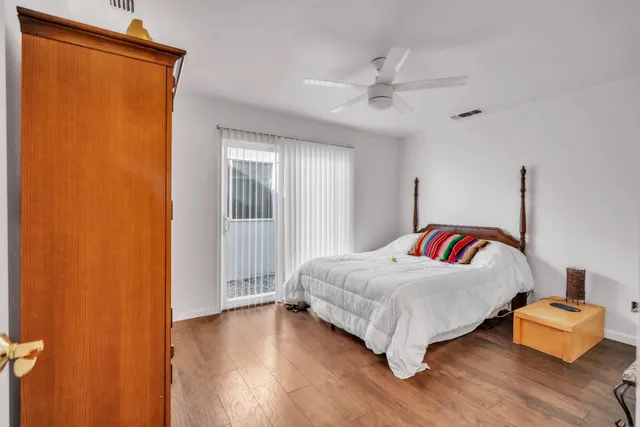 a view of a hallway with wooden floor and a living room