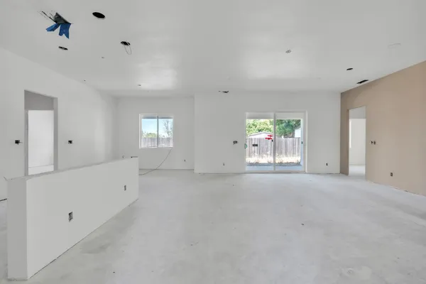 a view of a hallway with wooden floor and a kitchen