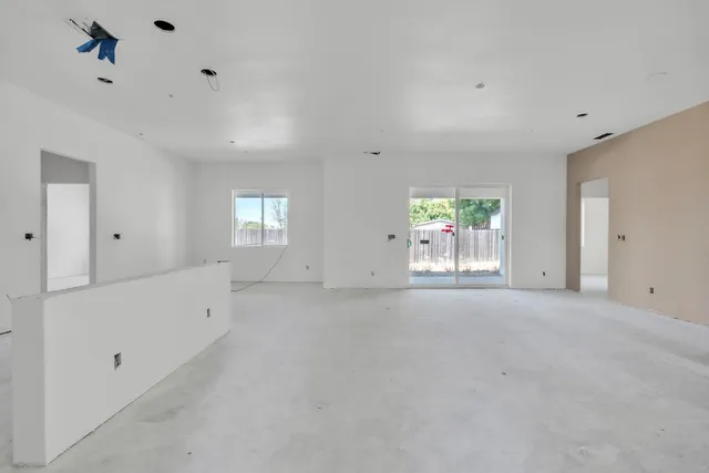a view of a hallway with wooden floor and a kitchen